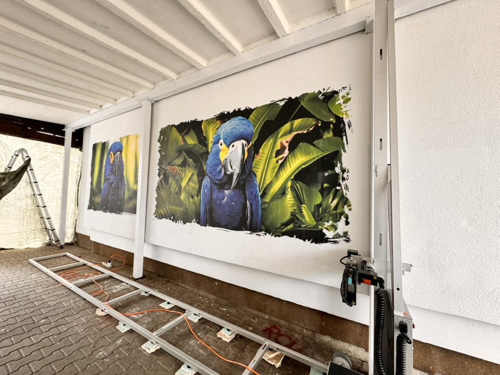 Ara wśród tropikalnych liści – mural wydrukowany na tynku w przejściu, SM Dąb Szczecin