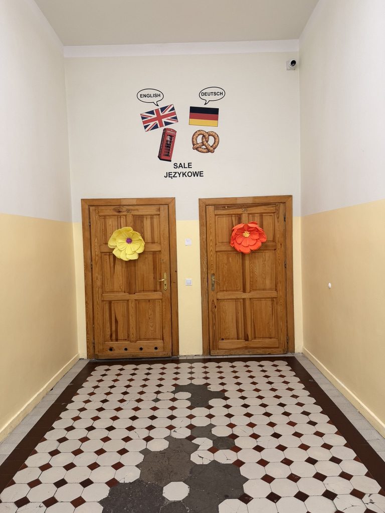 Napis SALE JĘZYKOWE z flagami Wielkiej Brytanii i Niemiec nad drzwiami sal językowych