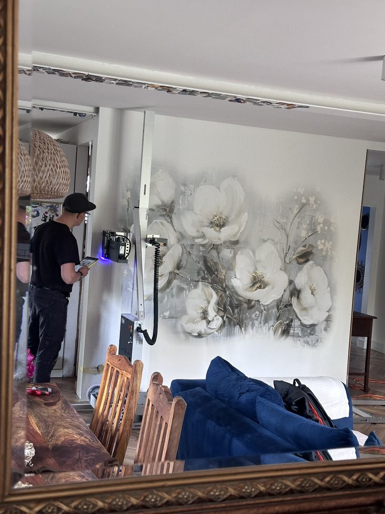 Mural z białymi kwiatami odbity w lustrze – salon w domu fotografki Ewy Papy w Mostach