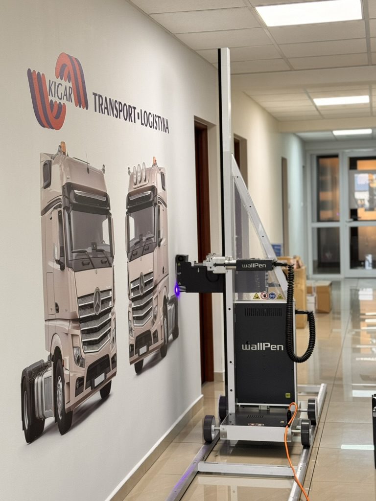 Logo KIGAR Transport Logistyka i dwa ciągniki siodłowe wydrukowane na ścianie korytarza biura w Goleniowie – drukarka WallPen E2