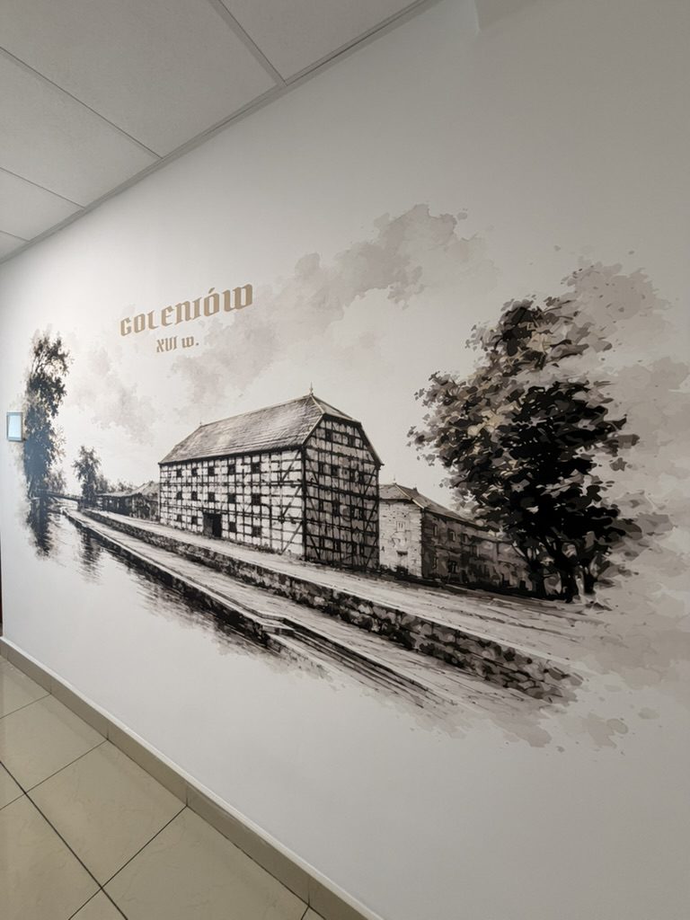 Grafika w stylu szkicu ołówkiem – dawny Goleniów z rzeką i drzewami na ścianie biurowca