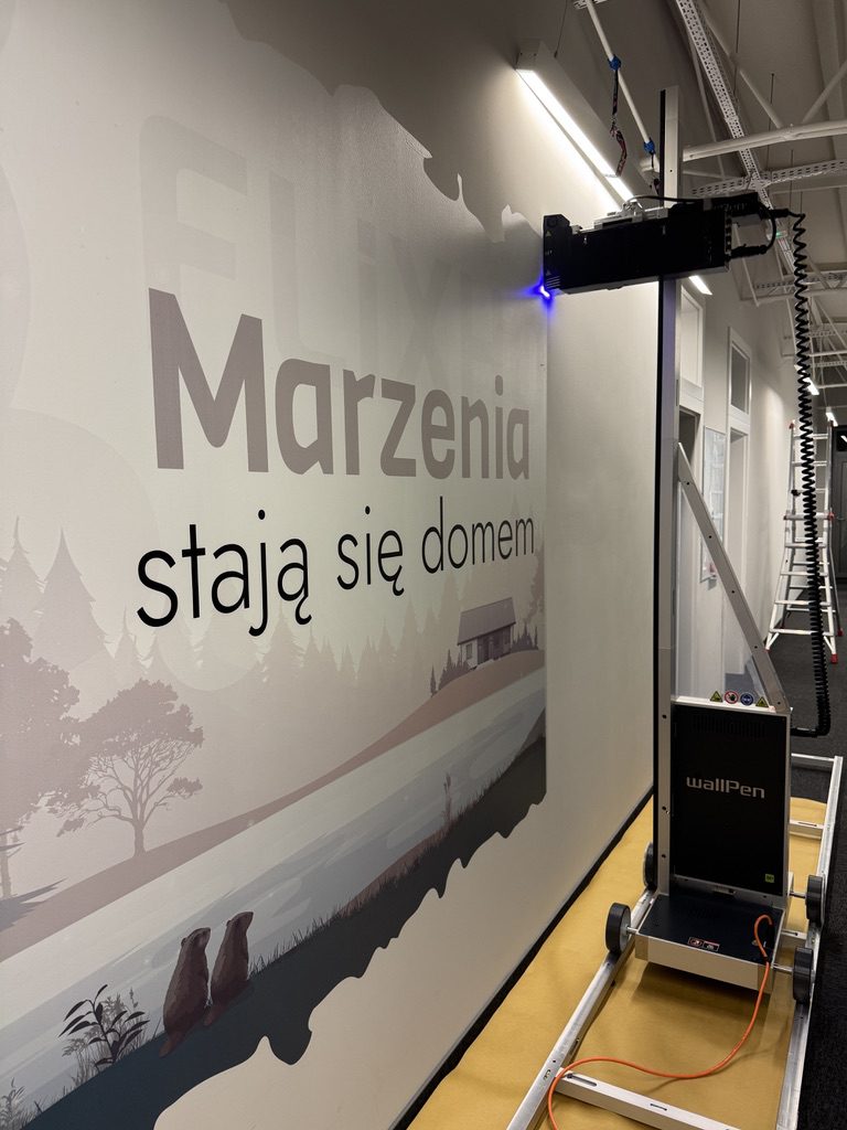 Drukarka WallPen E2 drukuje hasło Marzenia stają się domem w biurze FLiXHOME w Szczecinie