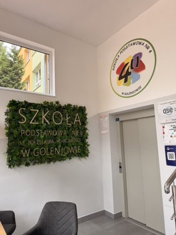 Logo Szkoły Podstawowej nr 4 w Goleniowie wydrukowane na ścianie przy wejściu do szkoły