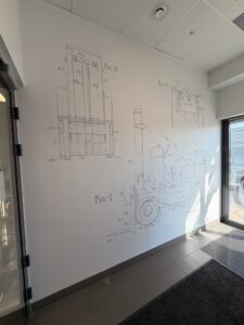 Rysunki techniczne wózka widłowego na ścianie – recepcja KION Polska w Kołbaskowie